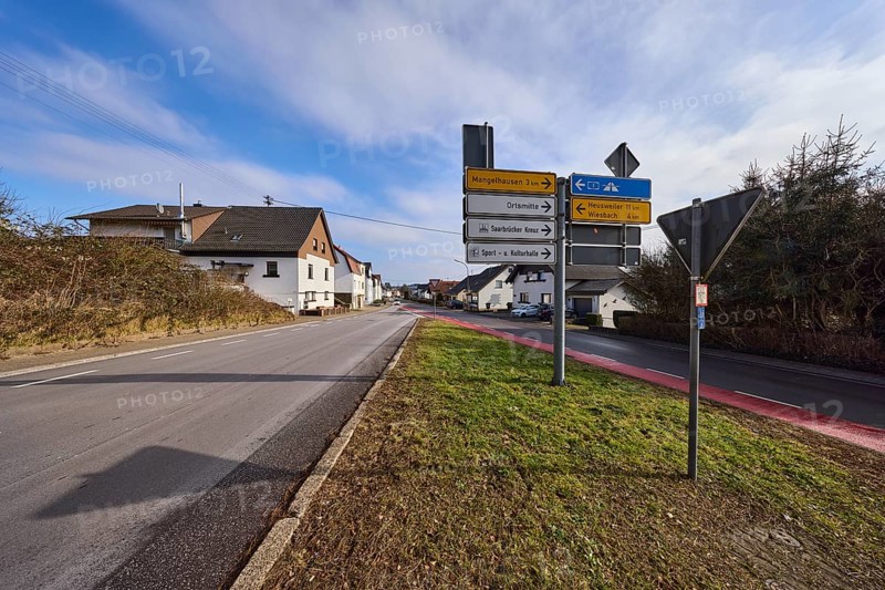 Signpost to the A1 motorway, Mangelhausen, Saarbrücker Kreuz industrial estate, Heusweiler, Wiesbach and town centre, residential buildings, trees, blue sky with cumulus clouds, intersection of Saarbrücker Straße and Ottweilerstraße, Illingen, Neunkirchen district, Saarland, Germany