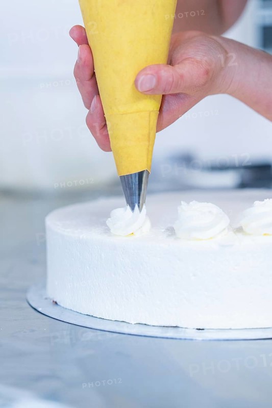 Cream is applied decoratively to a cake with a piping bag, cake baking, Haselstaller Hof Cafe Kuh, Wildberg, Black Forest, Germany
