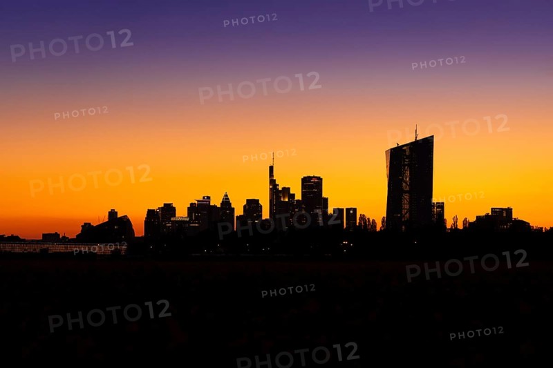 The silhouette of Frankfurt's banking skyline stands out against the glowing evening sky after sunset, Oberrad, Frankfurt am Main, Hesse, Germany