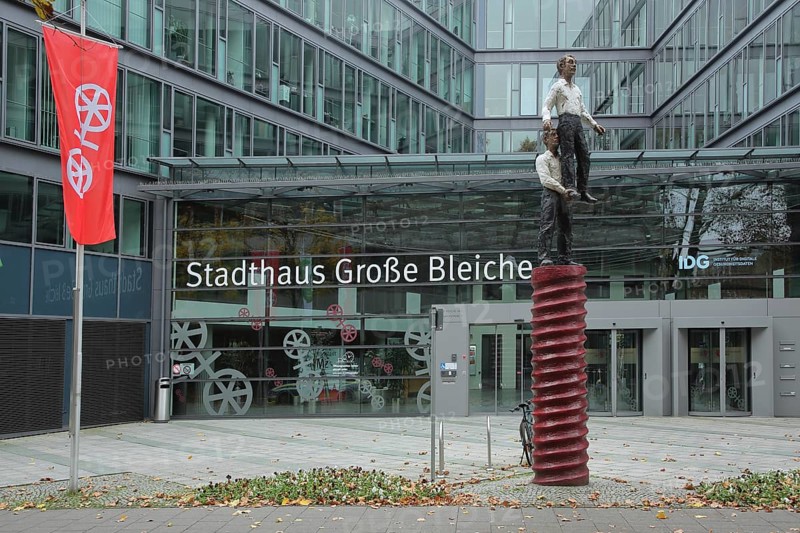 Entrance to the town hall with sculpture Two Men by Stephan Balkenhol 2001, male figure, standing on one leg, carrying, lifting, lifting, high, above, strength, acrobatics, glass window, inscription, glass construction, city flag, Große Bleiche, historic city centre, Mainz, Rhine-Hesse region, Rhineland-Palatinate, Germany
