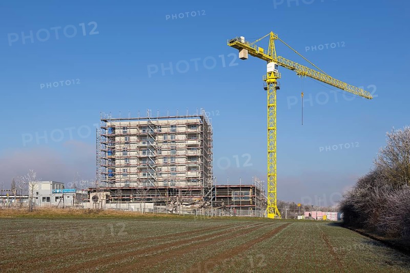 Yellow construction crane at an unfinished building on construction site, blue sky, housing construction, new construction of 50 flats, new development area, apartment building, construction site, Winnenden, Baden-Württemberg, Germany