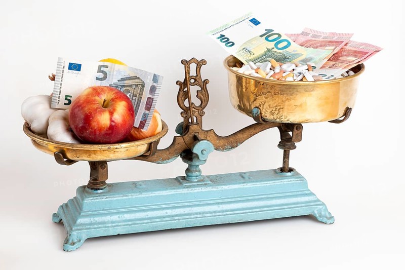 Old scales with medicine and apple opposite, euro notes, white background