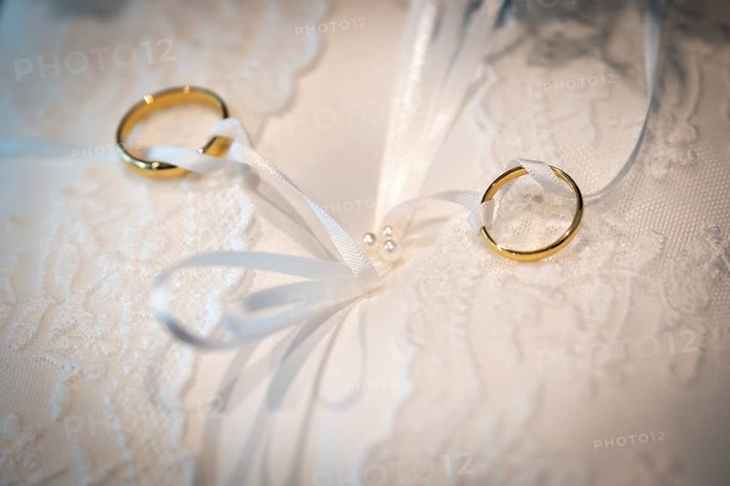 Wedding rings on an ornate white cushion