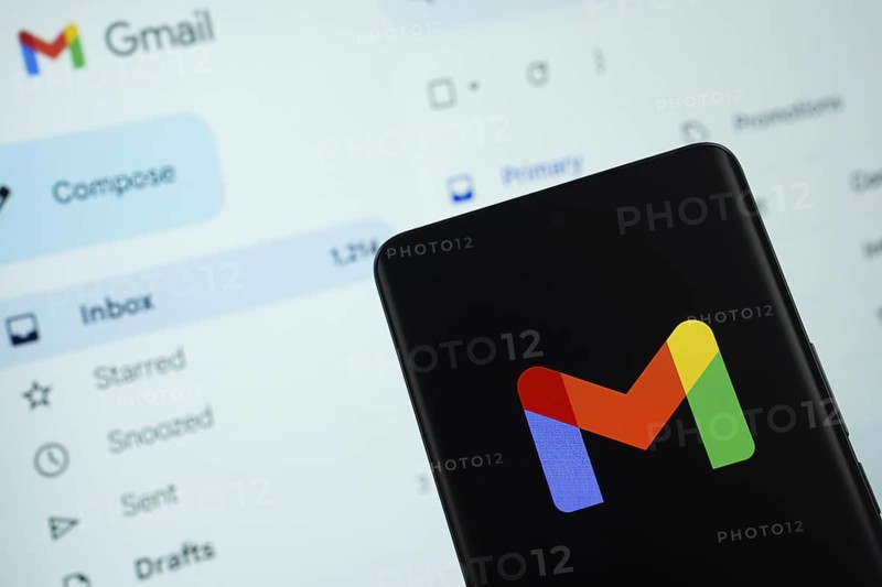 The logo of the Gmail is displayed on a smartphone screen, and the website gmail is visible on a computer screen in the background