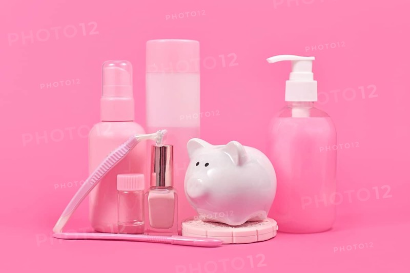 Pink tax concept with piggy bank and various stereotype pink colored hygiene product marketed to women
