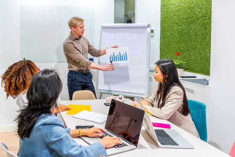 Business team analyzing marketing data during a productive meeting in a modern coworking office