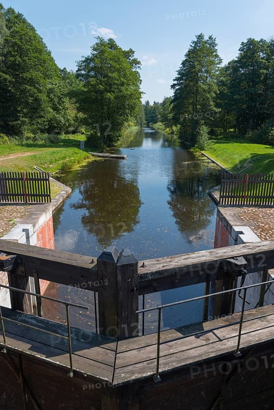 A wooden river lock leads into a forest that lines the water, Tartak Lock, Augustow Canal, Augustowski Canal, Suwalki, Podlaskie, Podlaskie, Poland