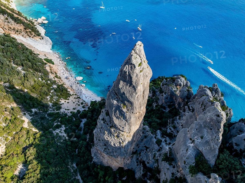 Picturesque rocky coast, cliffs with L'Aguglia pinnacle, blue sea and Cala Goloritzé beach, aerial view, Golfo di Orosei, Baunei, Sardinia, Italy