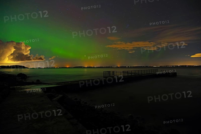 Northern Lights over a dark fjord, the shore in the background, starry sky, Tönsberg, Oslofjord, Norway