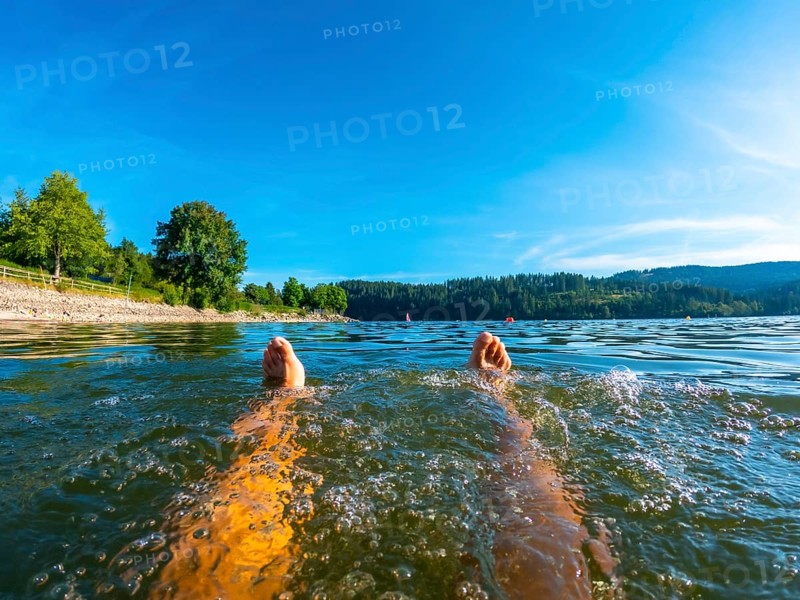 Feet of a man bathing in Lake Schluch in the Black Forest in Germany
