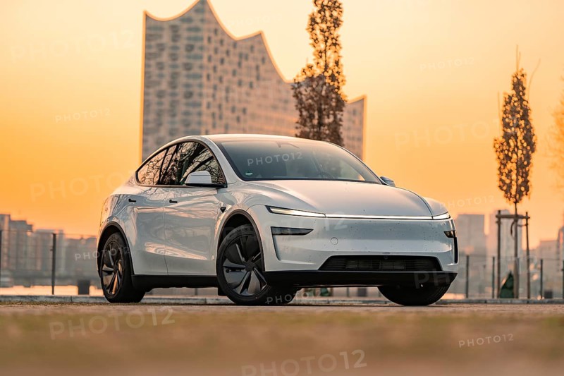 Futuristic white electric car in front of a modern building in the city at sunset, Tesla New Model Y, Germany