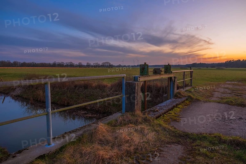 View of a sluice and a bridge with a pasture behind it at sunset, Kirchlinteln, Verden, Aller Leine Valley, Lower Saxony, Germany
