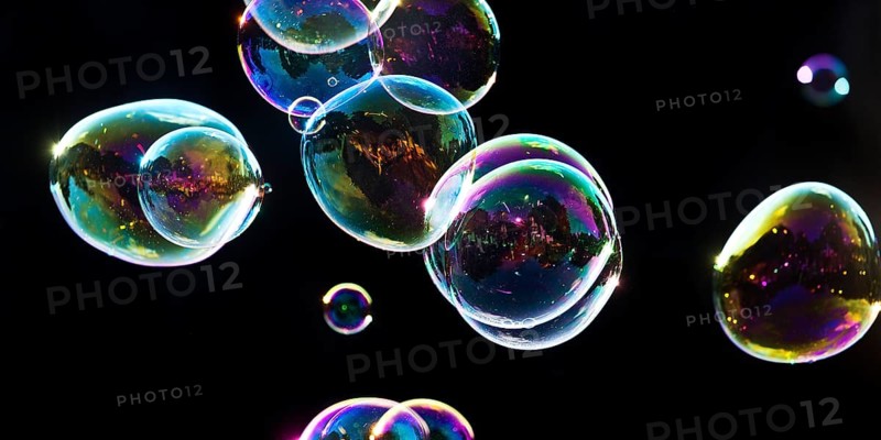 Iridescent soap bubbles in the colours of the rainbow against a black background, Recklinghausen, North Rhine-Westphalia, Germany