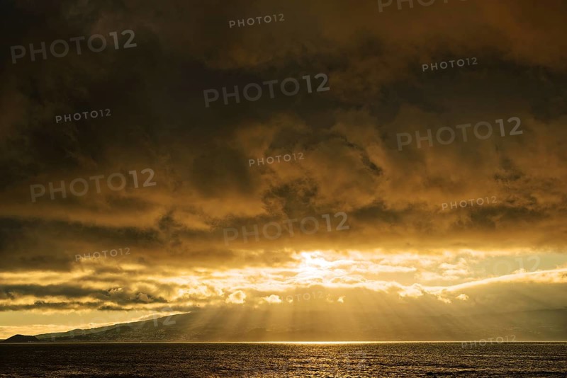 Dramatic sunset with sun rays breaking through the clouds over the sea, Criação Velha, Pico Island, Azores, Portugal