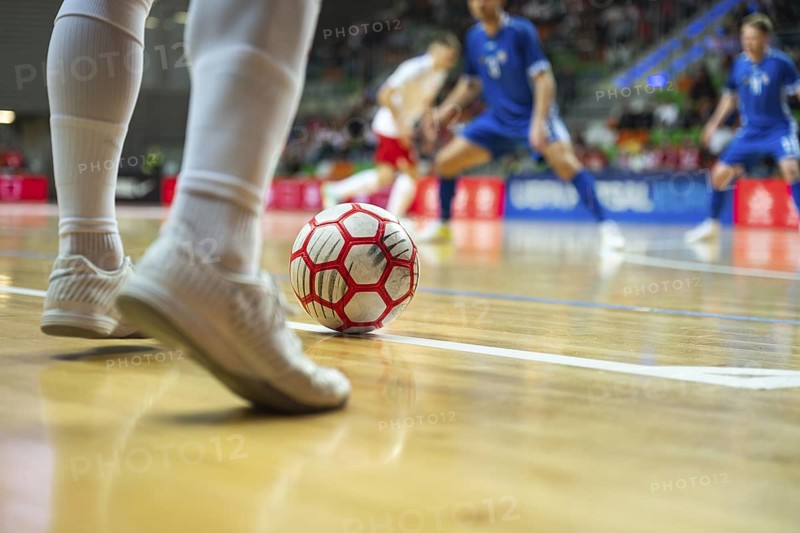 Detail of futsal ball and players legs