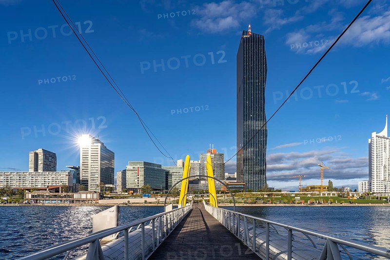 Pontoon bridge Ponte Cagrana and the skyline of Donau City in Vienna, Austria