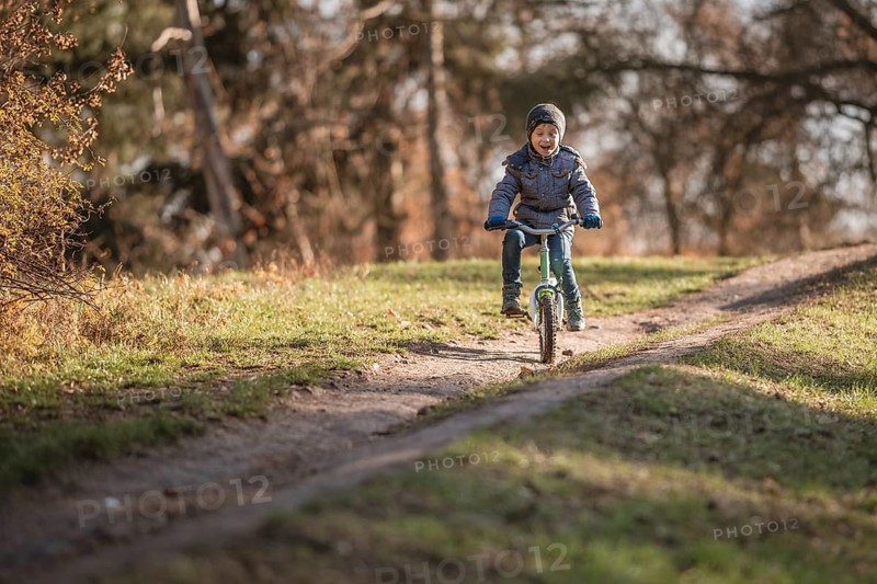 Six years old boy rides bicycle from the hill in the park