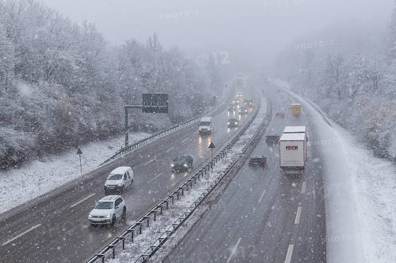 Winter motorway scene with passing vehicles, shrouded in fog and snow, Winnenden, Baden-Württemberg, Germany