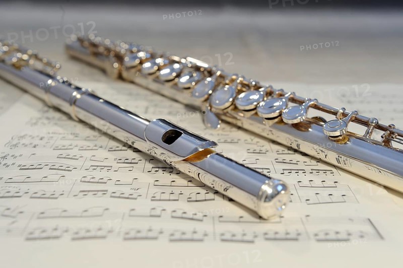 Silver flute lying on a sheet of music