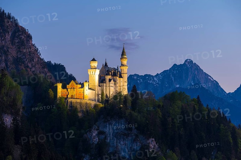 Fairytale castle illuminated in the evening Alps, Neuschwanstein, Schwangau near Füssen, Ostallgäu district, Swabia, Bavaria, Germany