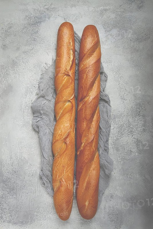 Fresh French baguette, two pieces, top view, on the table, no people