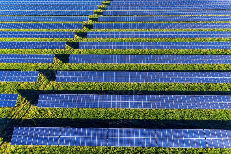 Aerial view over blue solar panels of photovoltaic power station, solar park for the supply of electricity
