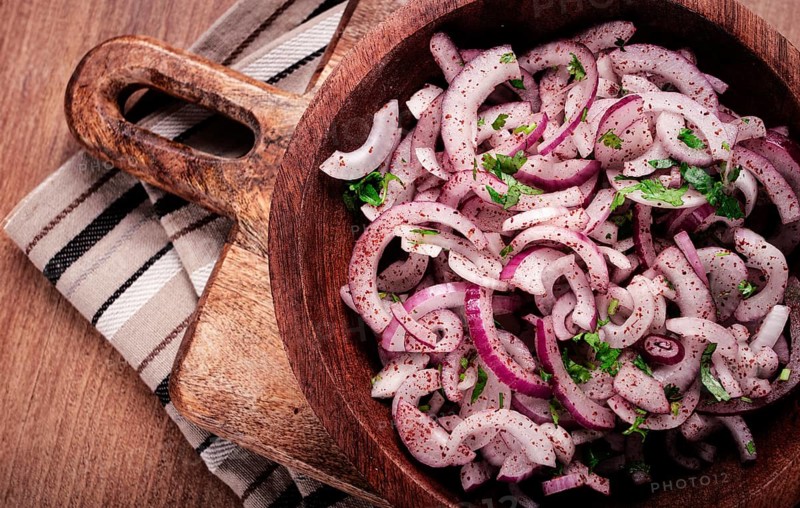 Chopped red onion, with sumac and herbs, in a bowl, pickled Spanish onion, close-up, top view
