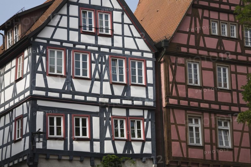 Half timbered white with black and burgundy with brown residential buildings with traditional terracotta ceramic tiled rooftops in the town of Bad Wimpfen, Germany