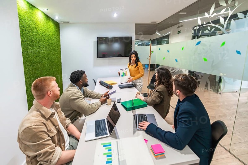 Diverse colleagues collaborating, analyzing marketing data, and developing strategies for successful campaigns in a contemporary office setting