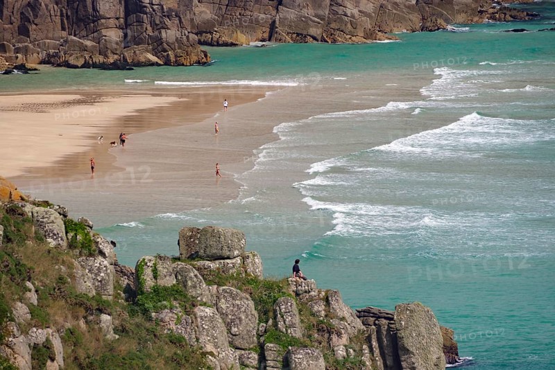 Blick auf Strand zwischen Klippen mit Menschen am Ufer und türkisfarbenem Meer, Aussichtspunkt, Porthcurno, St Levan, Cornwall, Großbritannien