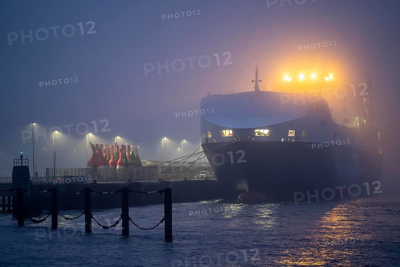 Thick fog in winter, hanging over the mouth of the Elbe into the North Sea, DFDS ferry Britannia Seaways at the pier in Cuxhaven, Lower Saxony, Germany