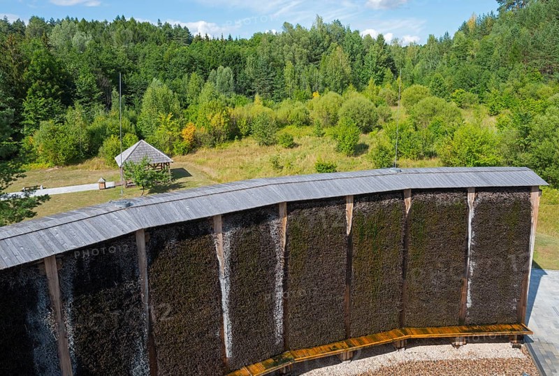 Curved wooden wall in front of a forest with lively green foliage under a blue sky, brine, graduation tower, spa town of Milomlyn, Milomlyn, Lviv, Warmia-Masuria, Poland