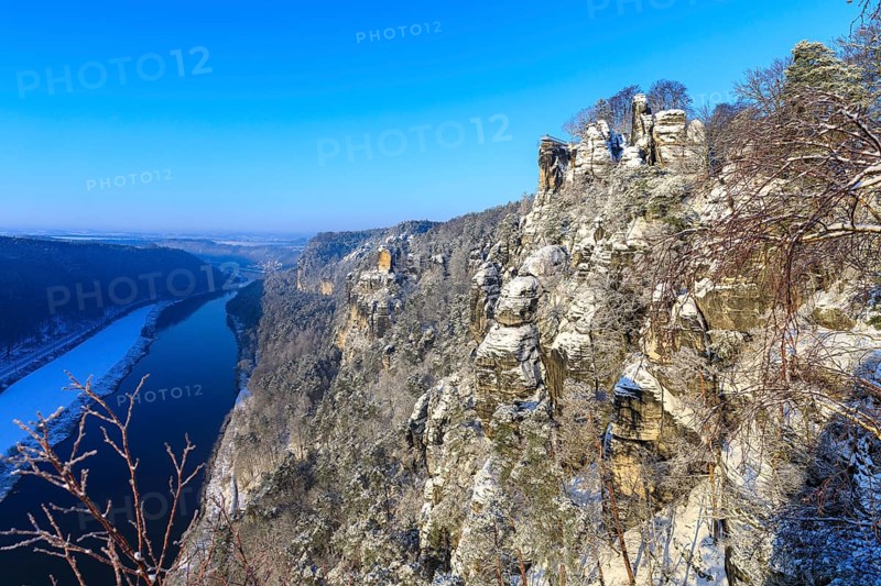Kanapee viewpoint at the Bastei into the snow-covered Elbe valley with sandstone cliffs such as the Wartturm and the floating viewing platform of the Basteiaussicht, Saxon Switzerland, Saxony, Germany