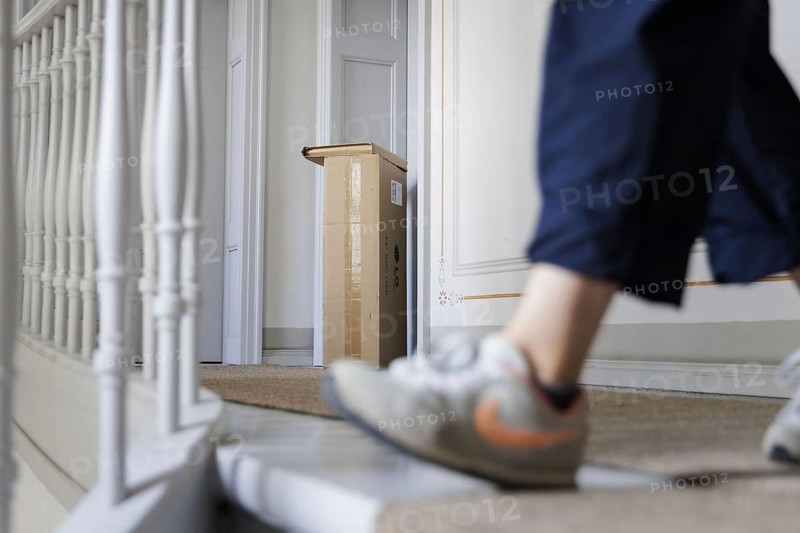 Parcel deliverer delivers a parcel to the front door in Berlin, 08.08.2024