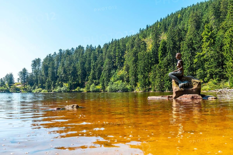 Beautiful landscape with the mermaid sculpture in summer at Mummel Lake or mummelsee, Black Forest, Germany