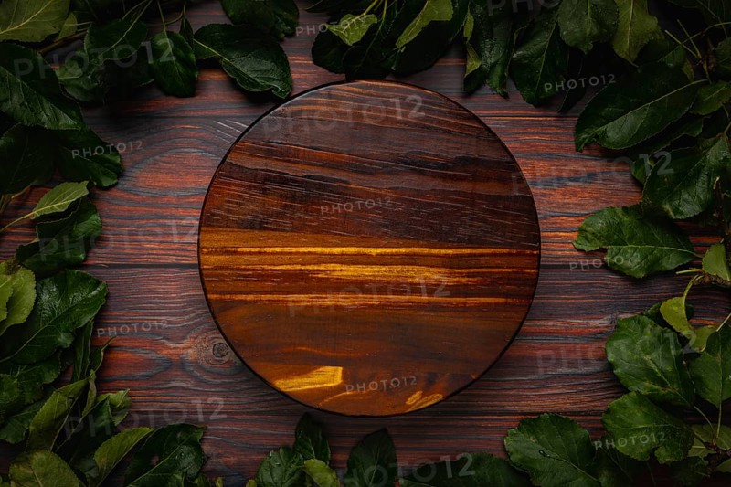 Frame of apple tree leaves on wood, round wooden board, copying room
