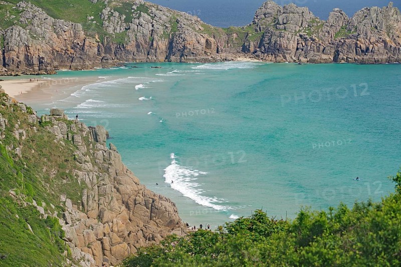Türkisfarbenes Meer zwischen steilen Klippen und grüner Landschaft, Porthcurno, St Levan, Cornwall, Großbritannien