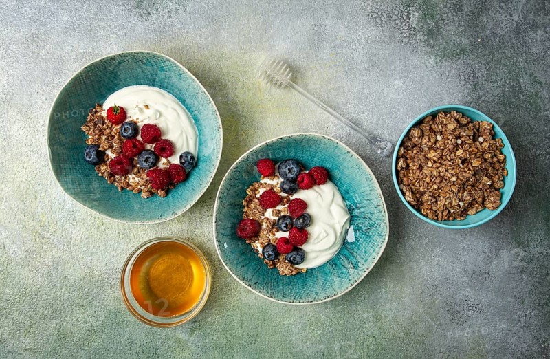 Breakfast, two bowls, yogurt, muesli with berries, and honey, homemade, no people