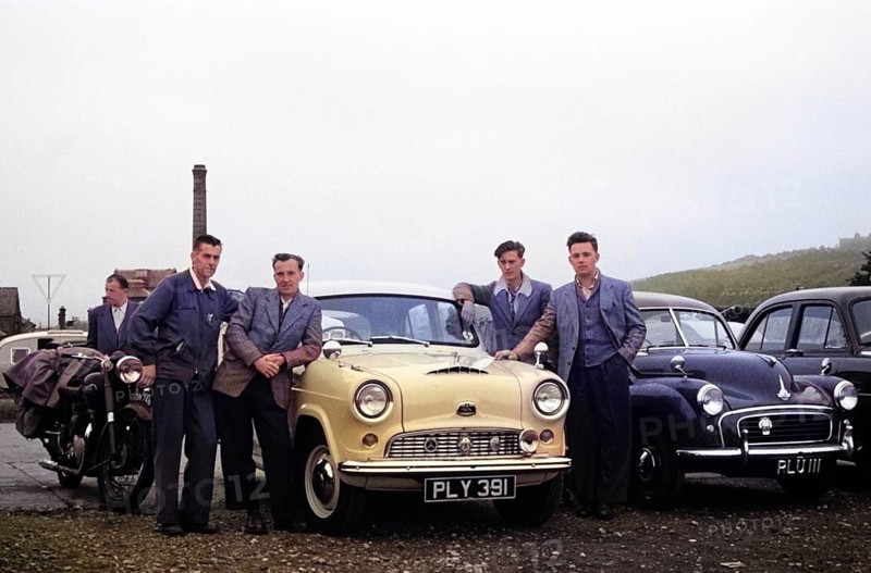 Four men standing by Austin Cambridge A40 car starting overland drive adventure across Europe, England, UK 1956 colourised Ektachrome slide