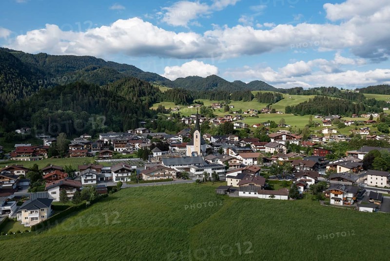 Drone shot, view of the village with parish church, Kössen, Leukental, Tyrol, Austria