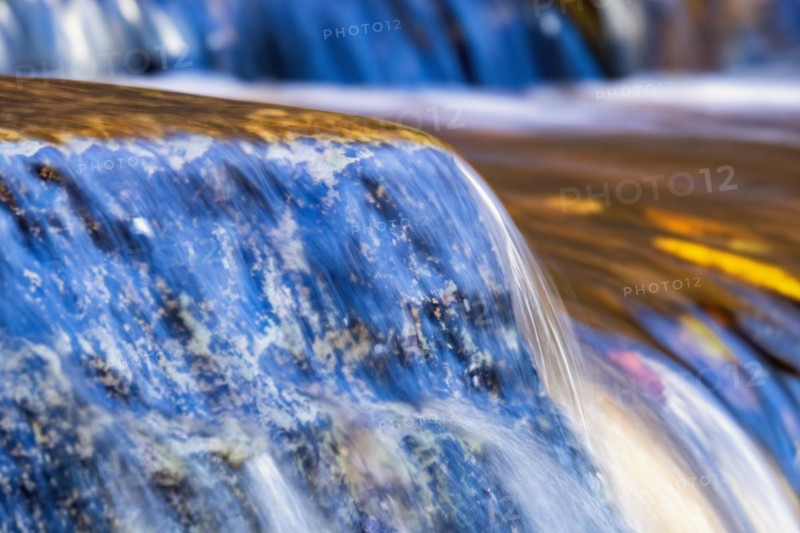 Close up at running water over a rock in a stream