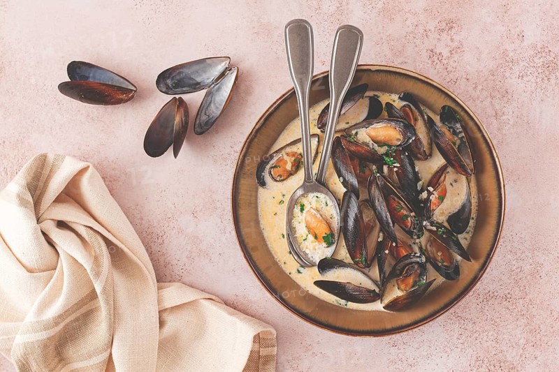 Mussels in creamy garlic sauce, served with fresh herbs and spices, homemade, no people