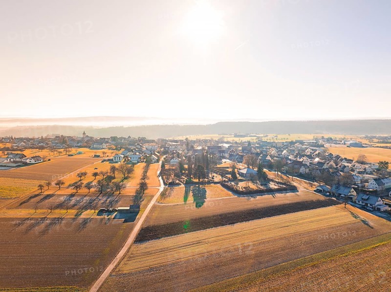Small village surrounded by fields under bright sun and autumnal atmosphere, Neubulach, Black Forest, Germany