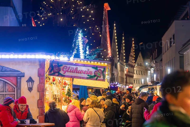 Festively illuminated mulled wine stand with many people in Christmas spirit, Christmas market, Nagold, Black Forest, Germany