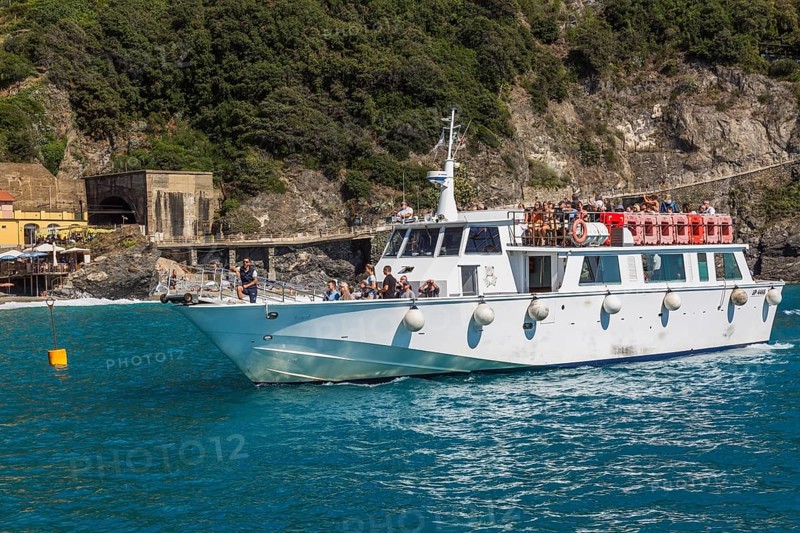 White shuttle service boat arriving in bay in late summer, Monterosso village, Cinque Terre, La Spezia province, Italy