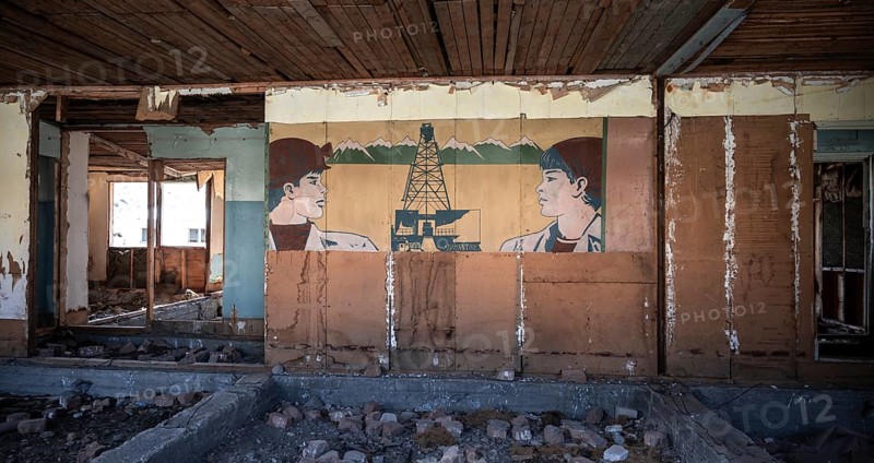 Destroyed abandoned classroom of the old school, wall painting with Soviet miners, ghost town, Engilchek, Tian Shan