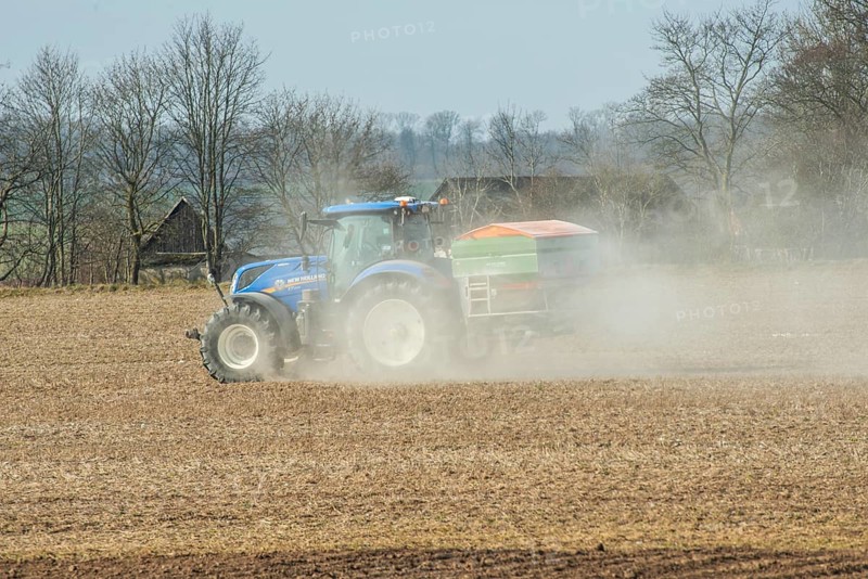Spring farming, spreading fertilizer with tractor on field in Ystad municipality, Skåne county, Sweden, Scandinavia