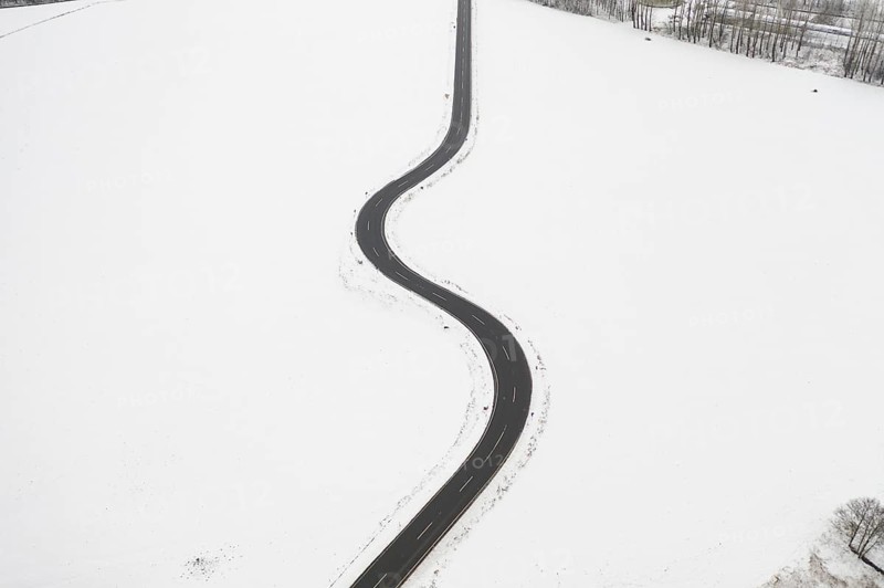 Aerial view of a winding country road in the snow, between Eppendorf and Leubsdorf, Central Saxony, Germany