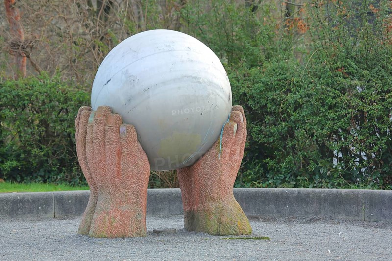 Sculpture The world in my hands by Hans Günther Thiele 2002, stone sculpture, modern art, globe, earth, sphere, stone ball, hands, fingers, carry, hold, protect, guard, protect, guarding, protection, symbol, sign, Dr.-Hans-Wolf-Platz, Pfingstweide, Oppau, Ludwigshafen am Rhein, Rhineland-Palatinate, Germany
