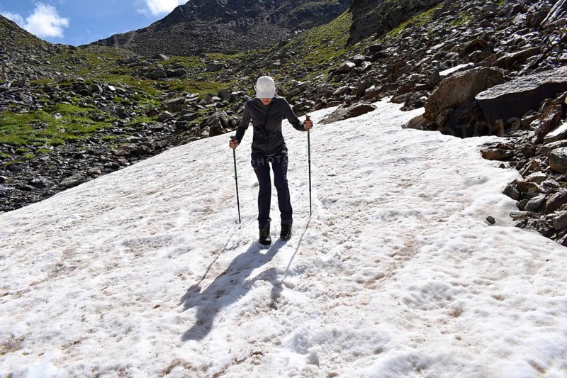 Mountaineer slips over a not very dangerous snowfield on the descent from the Weiße Spitze, Deferegger Alps, Hohe Tauern, East Tyrol, Austria